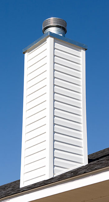White prefab chimney with silver cover on home