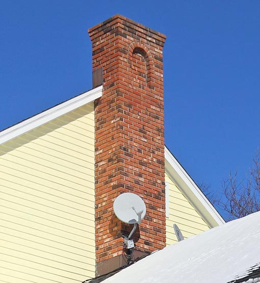 Image of Tall Masonry Chimney blue sky in background