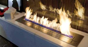 Gas Fireplace burning surrounded by metal on granite