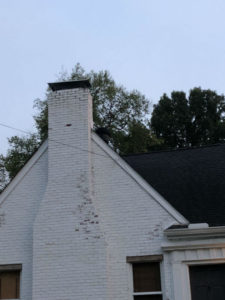 Home with white brick chimney and metal cap