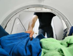 man getting laundry out of dryer