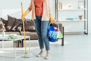 woman holding mop and bucket cleaning home